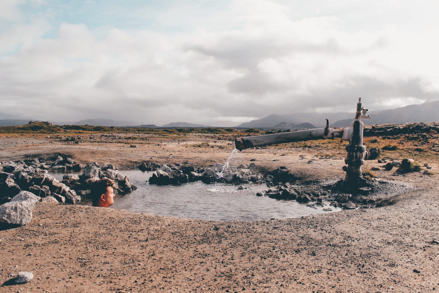 Maður situr í náttúrulaug