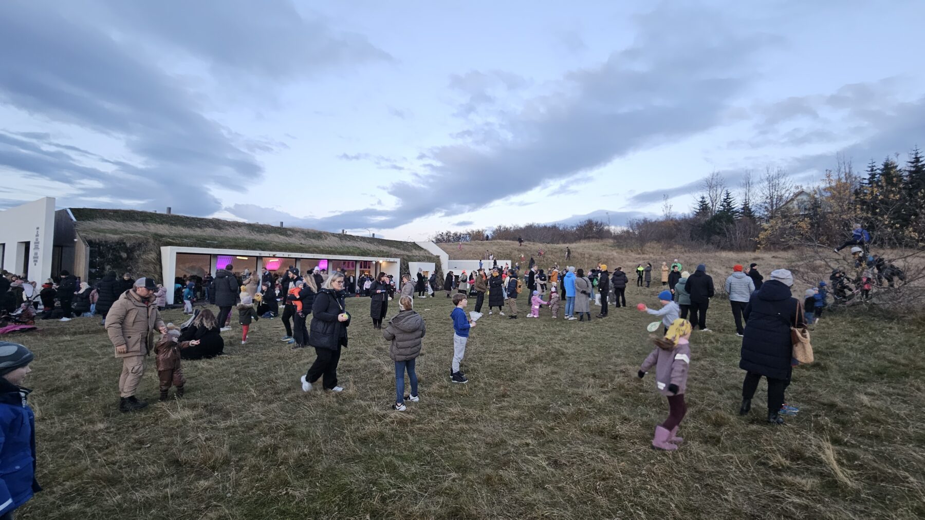 Fólk á víð og dreif á túni fyrir utan Höfuðstöðina.